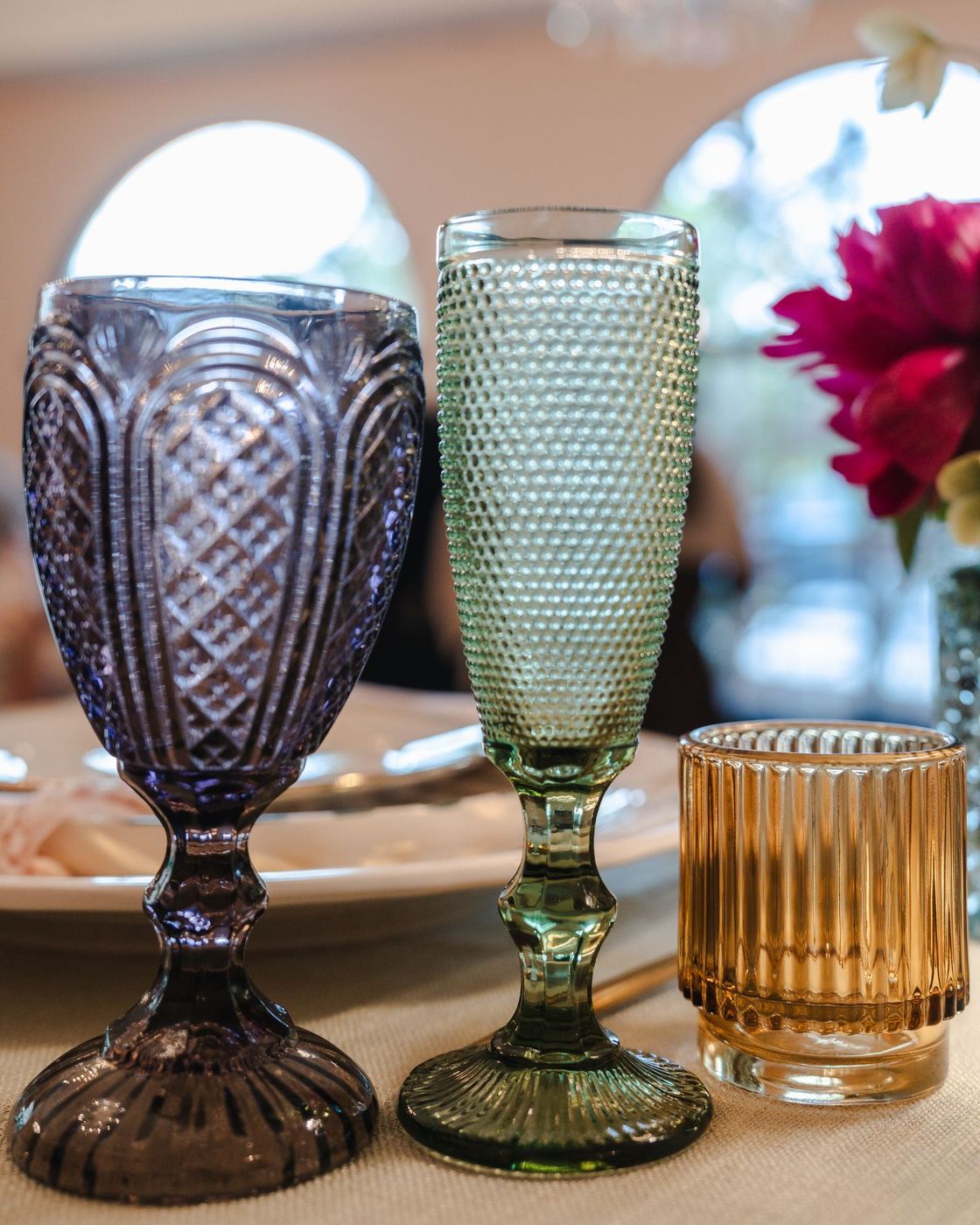 Carousel Purple goblet beside an olive green Capri champagne flute
